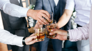 Grupa przyjaciół świętujących na wieczorze kawalerskim, śmiejących się i cieszących wspólnym czasem.